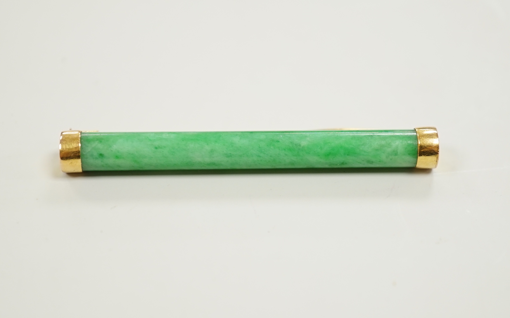 A Chinese yellow metal and cylindrical jade set bar brooch, 53mm, gross 5.6 grams.